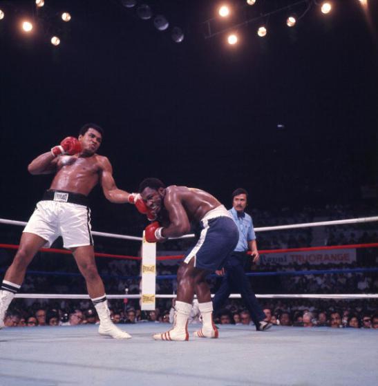 American boxer Muhammad Ali (born Cassius Clay) (left) throws a punch at Joe Frazier (1944 - 2011) during their bout in the ring at Araneta Coliseum, Quezon City, Philippines, October 1, 1975. Referee Carlos Padilla is visible in center. The fight, billed as 'the Thrilla in Manila,' was the third time the men had fought and this time, Ali emerged victorious. (Photo by Lawrence Schiller/Polaris Communications/Getty Images)