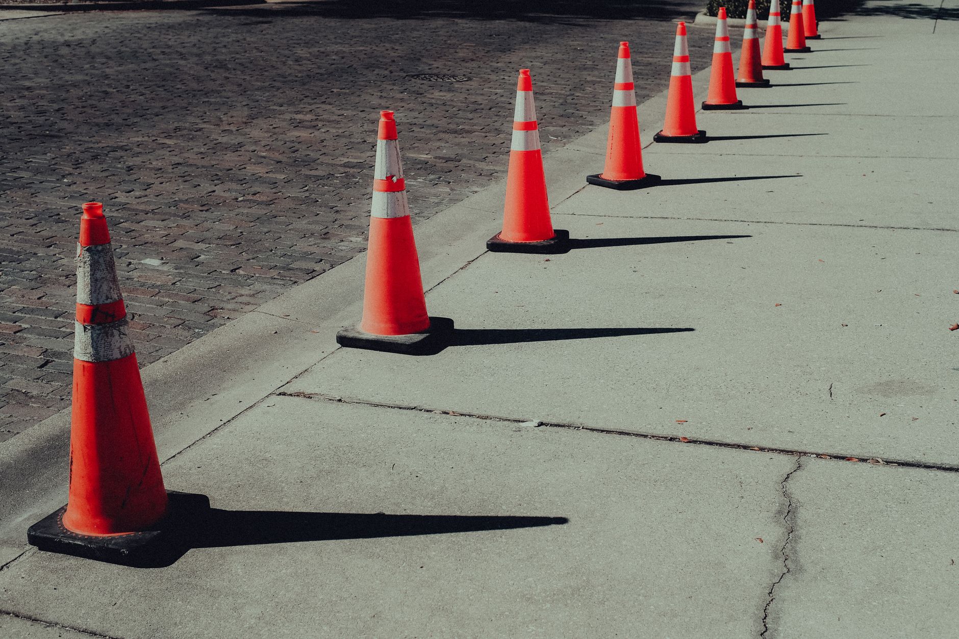 A row of orange traffic cones by a street