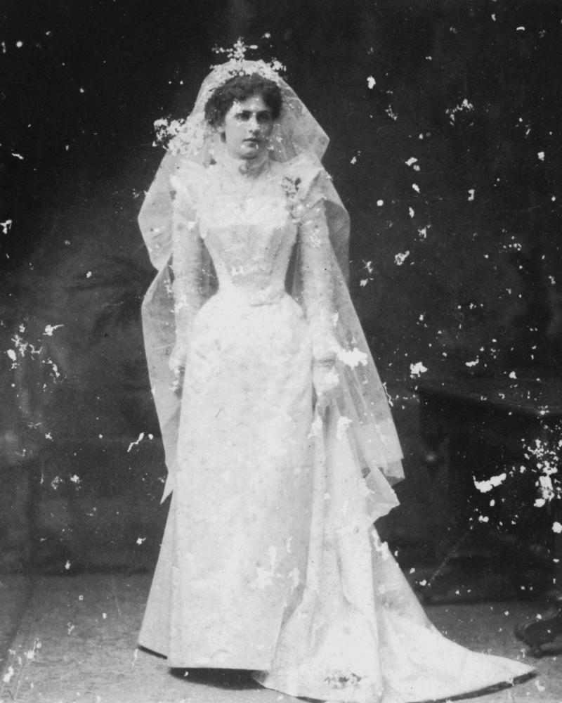 A bride in a long lace veil, photographed in the 1890s