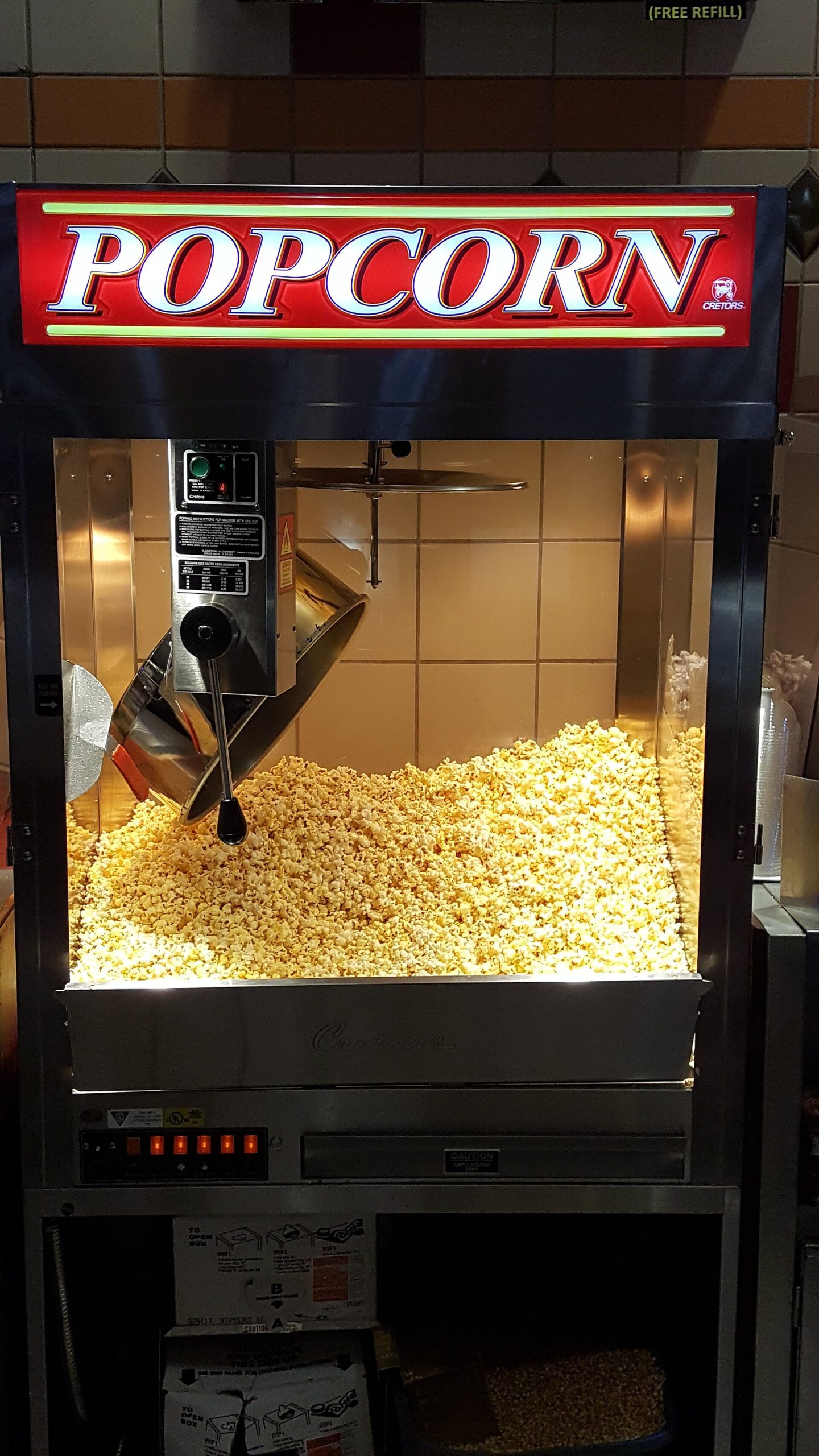 A popcorn machine in a movie theater lobby